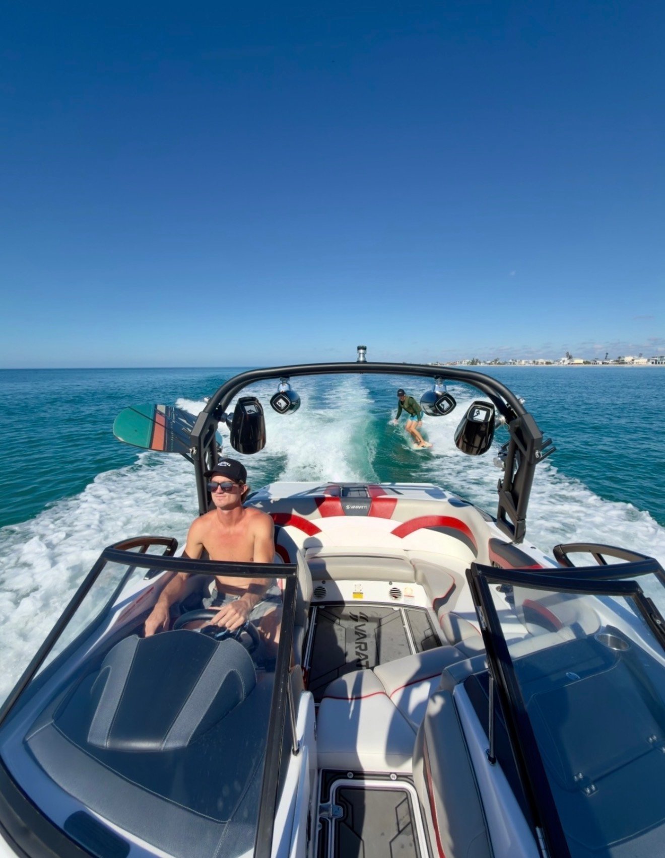 Captain ET at the helm with a surfer on the wake