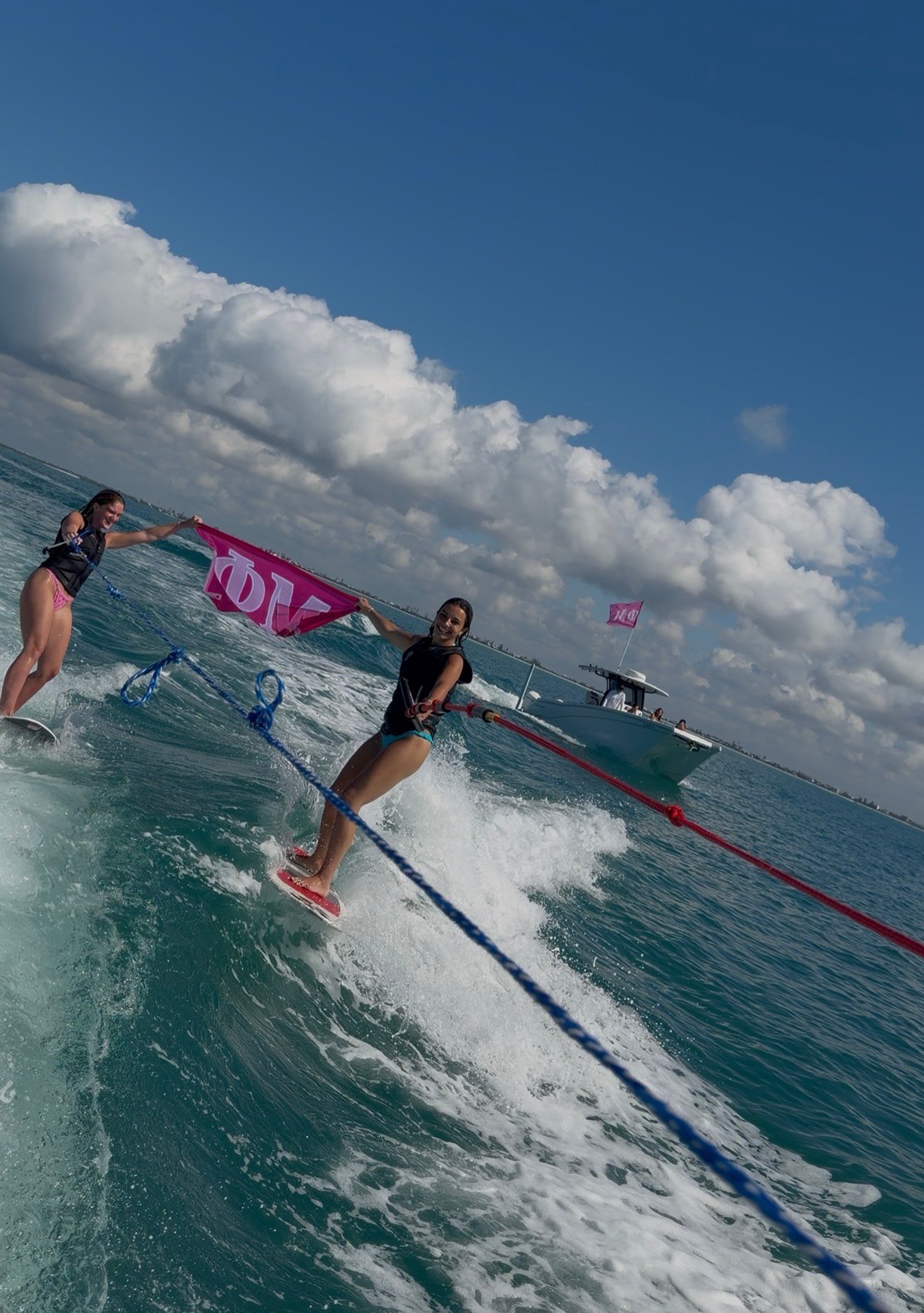 PhiMu sorority members wakesurfing and flying their flag